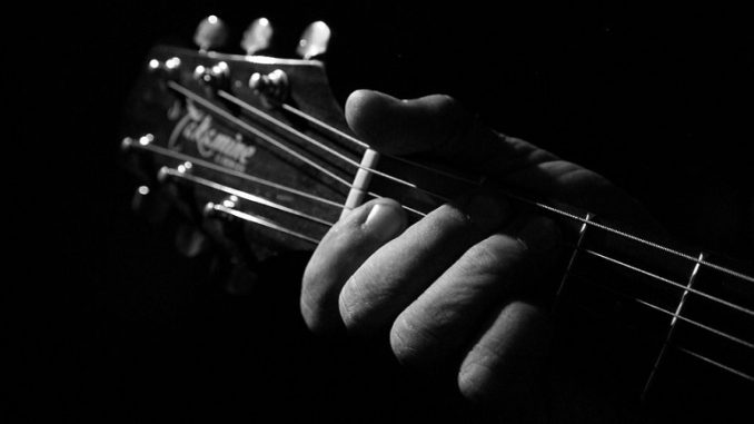 "Black And White Guitar Playing Edited 2020" by chocolatedazzles is licensed under CC BY 2.0